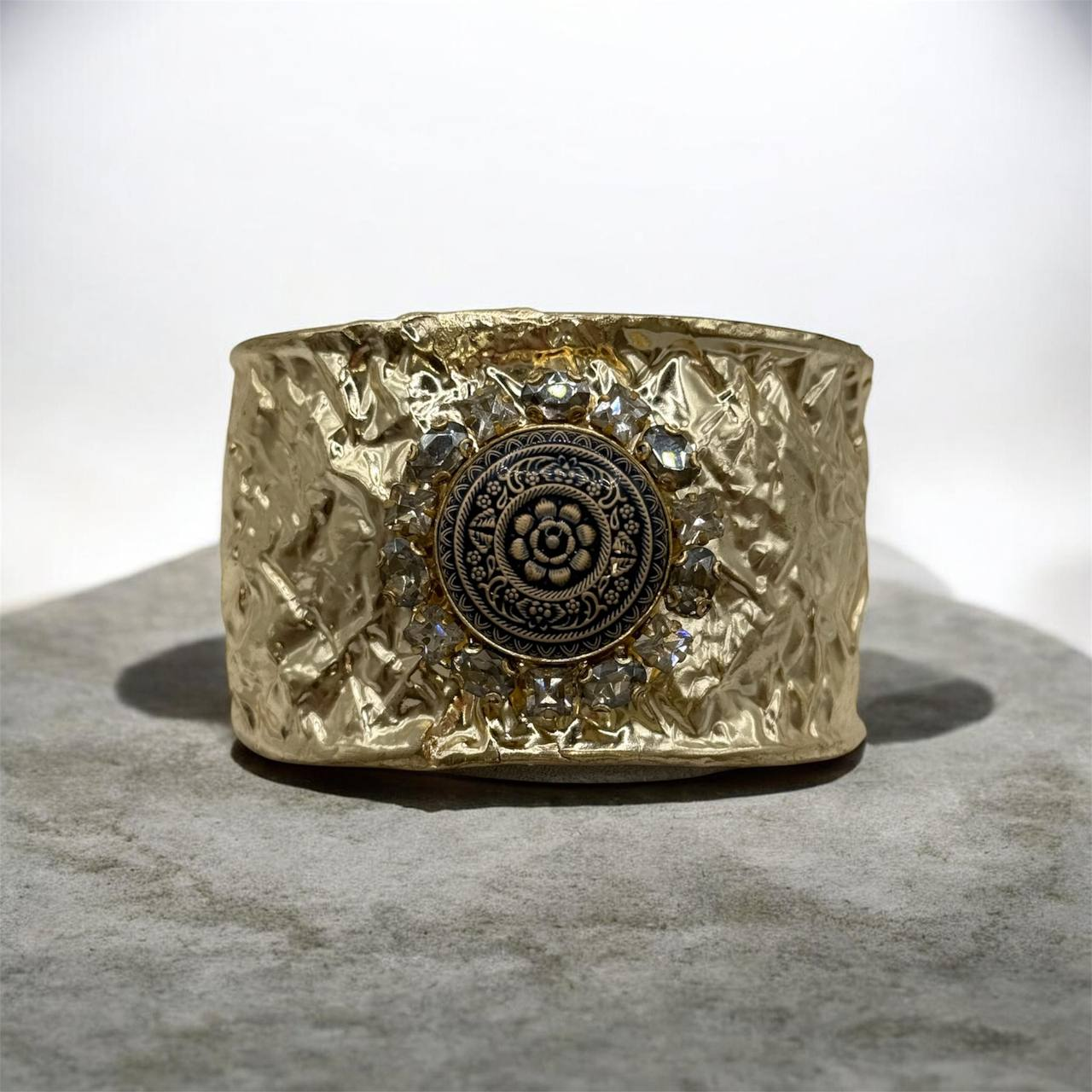 Браслет Monika выполнен из латуни и покрыт золотом. Украшен орнаментом и недрагоценными камнями.